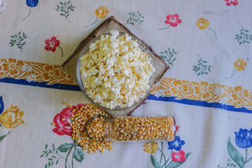 glass bowl with popcorn and corn seeds