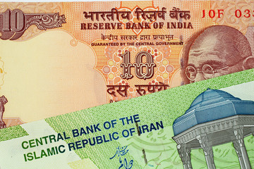 A close up image of an Indian 10 rupee bank note with an Iranian 10000 rial note