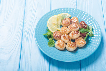 Fried scallops with lemon and salad