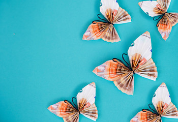paper money butterflies on blue background