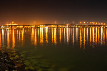 Fototapeta na wymiar Tauranga Harbour Bridge and surrounds illuminates night sky and harbour