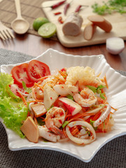 Thai yum salad hot and spicy with shrimp, squid, Vietnamese sausage, sausage, krab sticks and vegetables. Yum salad is a Thai local food, Spicy sour and sweet taste. © poravute