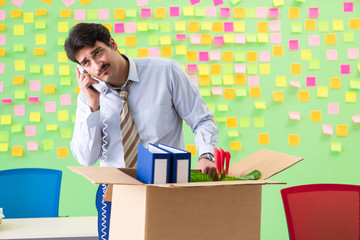 Man collecting his stuff after redundancy in the office with man
