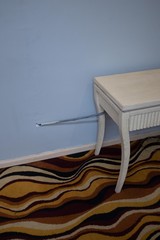 Antique style painted table with cable directly entering a wall