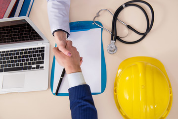 Doctor and manager agreeing industrial insurance coverage