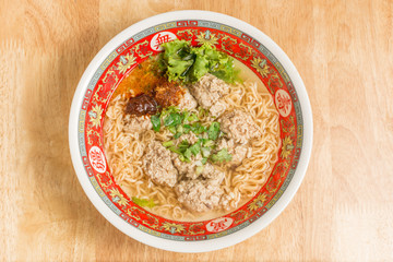 Close up of Instant noodle with meat ball and green Coriander on wood table