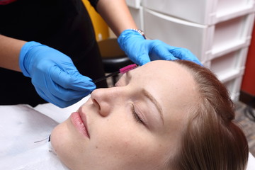 Fototapeta na wymiar applying Tottoo, Brow Microblading to customer eyebrows