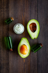Organic cosmetics with natural ingredients. Avocado essential oil near half of avocado on dark...