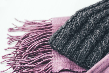 Gray woolen knitted hat and pink scarf on a white background - 219888821