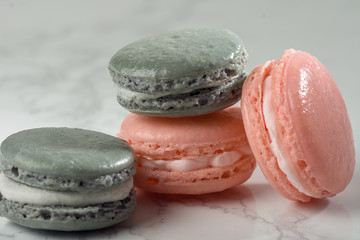4 French Macarons With Pastel Colors Arranged On A Marble Table.