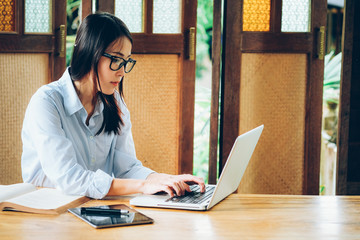 Beautiful asian business woman working with laptop, mobile phone and tablet in vintage tone.