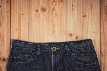 Frayed jeans or blue jeans denim collection on rough wooden table background with copy space, old...