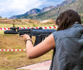 Girl shoots from an automatic weapon
