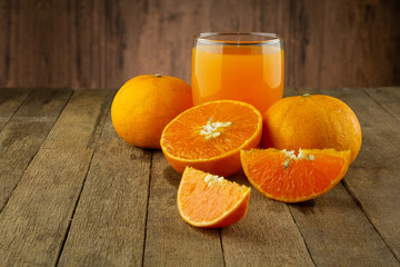 Glass of fresh orange juice on vintage wood table with copy space 