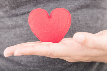 Fototapeta premium red heart in human hand with dramatic tone