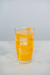 Orange juice soda mix on marble tile background.