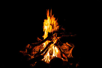 Close-up of a fire with an orange and red flame burning in the dark