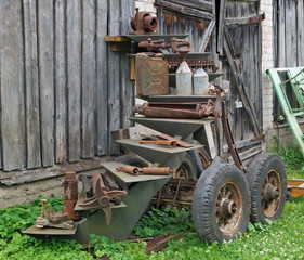 Rusty  vintage  small  tractors  spar parts and retrol machinery near rural shed.
