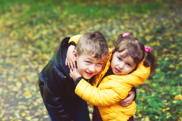 Cheerful children on a walk in the autumn Park . Brother and sister on a walk