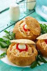 Snack on the festive table. Bun stuffed with shrimp salad and red caviar.