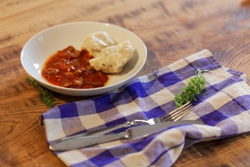 South Tyrolian cheese dumplings with tomato sauce on a white plate