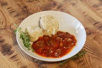 South Tyrolian cheese dumplings with tomato sauce on a white plate