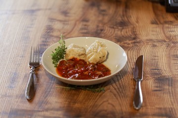 South Tyrolian cheese dumplings with tomato sauce on a white plate