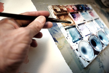 Fototapeta na wymiar Artist's hand holding paintbrush