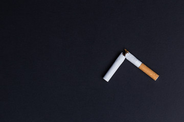 Broken cigarette on black background close-up
