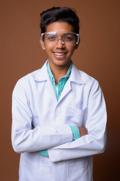 Young Indian Boy Doctor Wearing Protective Glasses Against Brown