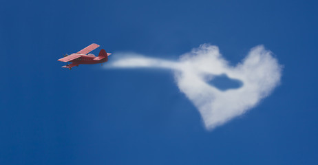 airplane flying in the cloud with love heart shape