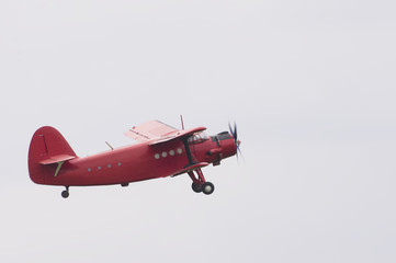 vintage red airplane flying in the sky