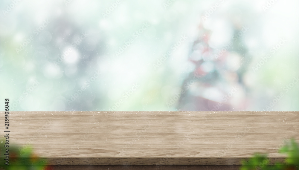 Poster Empty wooden table with abstract blur christmas tree and snow falling background with bokeh,Holiday backdrop,Mock up banner for display of product for promotion online.