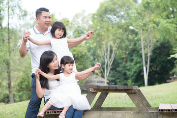 Naklejka na ściany i meble Happy Asian family at outdoor with empty table space.