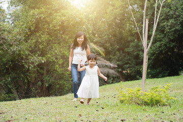 Mother and little girl chasing outdoors