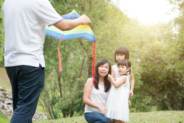Fototapeta premium Asian family flying kite outdoors.