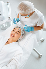 Helpful beauty procedure. Joyful positive woman smiling while enjoying the MCT procedure