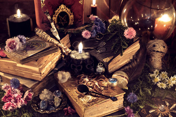 Still life with old magic books and ritual objects in mystic candlelight. Mystic background with...