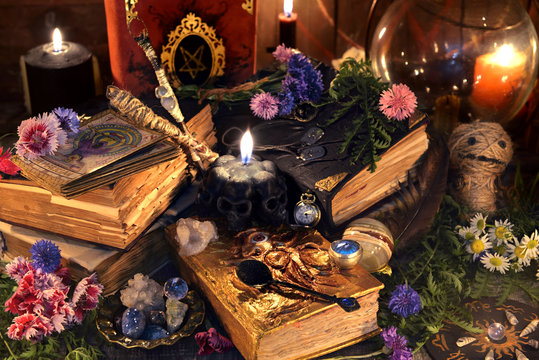 Still life with old witch books, antique lamp, black candles, voodoo doll and ritual objects. Mystic background with ritual esoteric objects, occult, fortune telling and halloween concept
