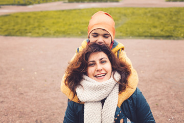 Cute mother and child boy hugging, outdoors portrait.  Love care and family positive relations. Mum and son together.