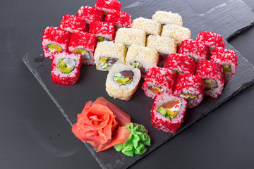 Obraz na płótnie Canvas Japanese restaurant, sushi roll on black slate plate.