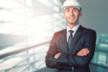 Fototapeta premium Young handsome engineer in white hardhat