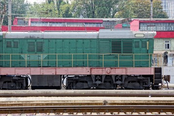 an iron green locomotive stands at a railway station