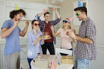 Obraz premium Friends with cake celebrating birthday at a party in room.