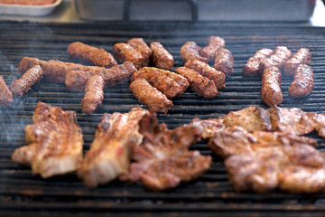Street food being made in state fair. Traditional meat and sausages grilled in open air market for people. First barbecue party outdoors in spring
