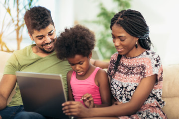African american family using laptop in the living room.