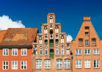 Facades of the old historiacal buildings made of red brick. Blue sky on the background. Luneburg, Germany