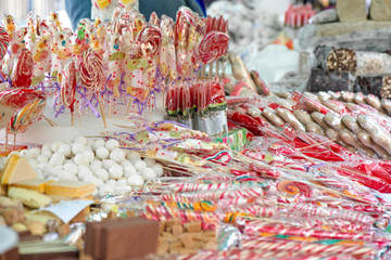 Natural honey sourced sweet candy in different shapes and colorful designs at a local state fair. Sweets and lollipops for kids. Concept of unhealthy eating, too much sugar. Diabetes