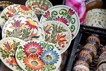 Traditional Romanian painted clay pots used for Easter meals. Decorations and ornaments on bowl. Beautiful kitchen decor. People buying kitchen supplies in local market
