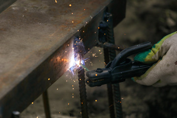 Worker welds metal at the construction site